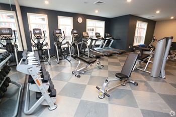 a gym with cardio equipment and weights on a checkered floor at Century Baxter Avenue, Louisville, 40204